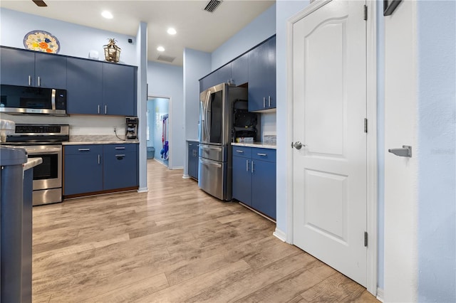 kitchen with blue cabinetry, appliances with stainless steel finishes, and light hardwood / wood-style floors