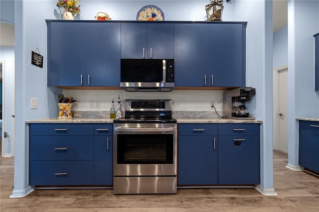 kitchen featuring blue cabinetry and appliances with stainless steel finishes