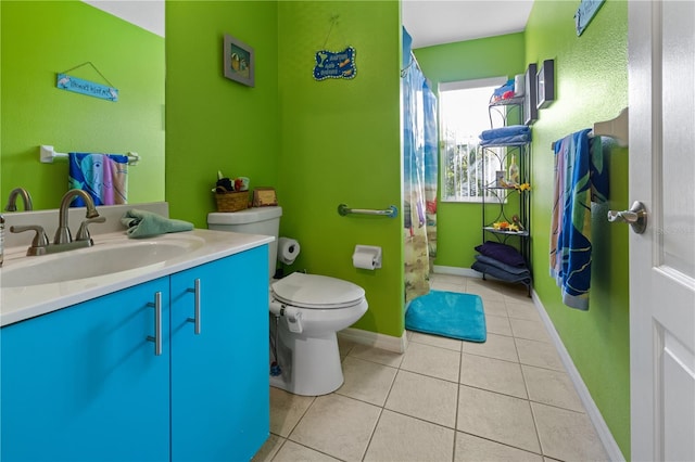 bathroom with toilet, vanity, and tile patterned floors