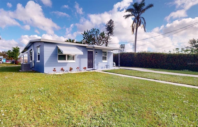 view of front of property featuring cooling unit and a front yard