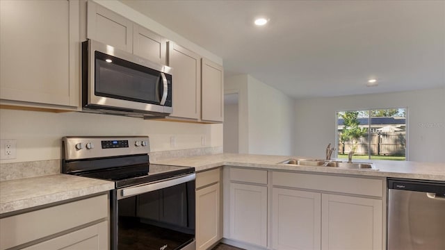 kitchen featuring kitchen peninsula, sink, and appliances with stainless steel finishes