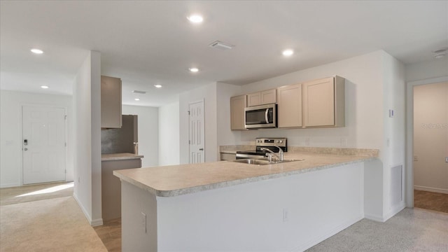 kitchen featuring light colored carpet, kitchen peninsula, sink, and appliances with stainless steel finishes