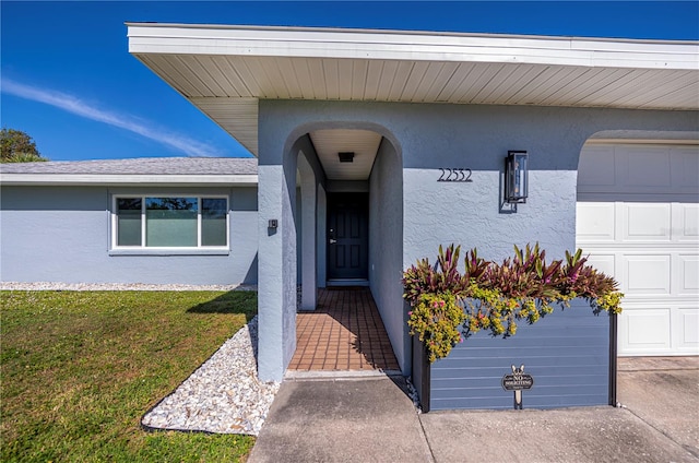 doorway to property featuring a yard and a garage