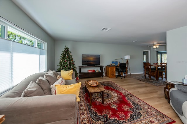 living room with plenty of natural light, light hardwood / wood-style floors, and ceiling fan