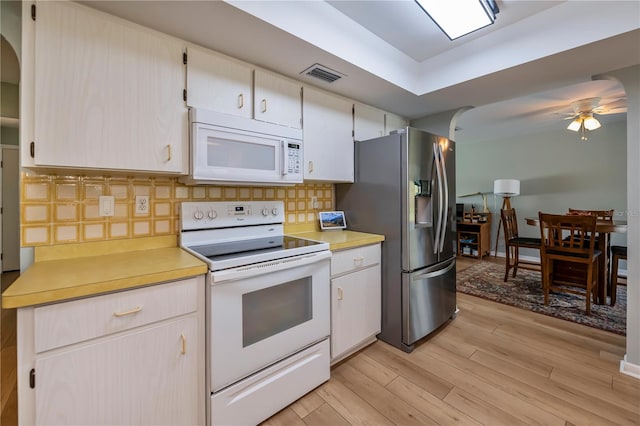 kitchen with tasteful backsplash, ceiling fan, white appliances, and light wood-type flooring