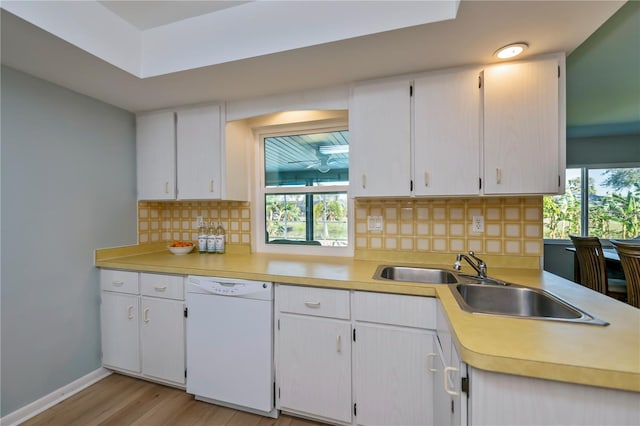 kitchen featuring white cabinetry, dishwasher, sink, backsplash, and light hardwood / wood-style floors