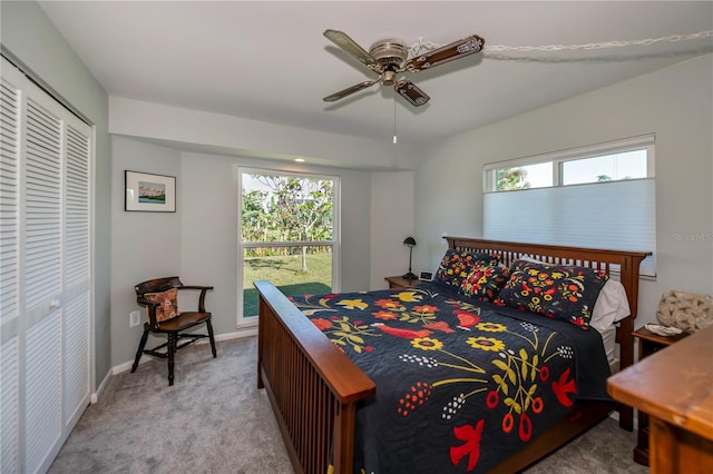 bedroom featuring ceiling fan, a closet, and light carpet