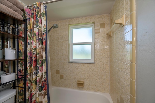 bathroom featuring shower / bath combination with curtain and toilet