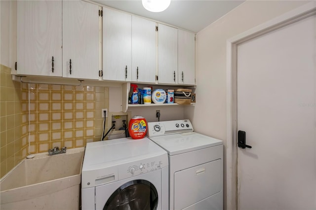 laundry area featuring cabinets, washing machine and dryer, and sink