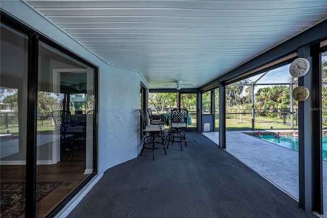 unfurnished sunroom with a pool and ceiling fan