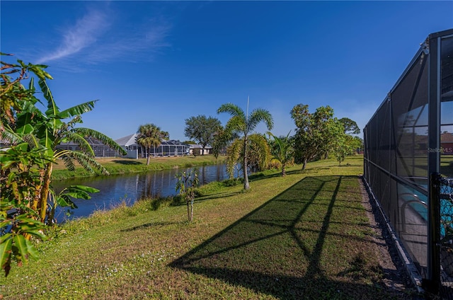 view of yard with glass enclosure and a water view