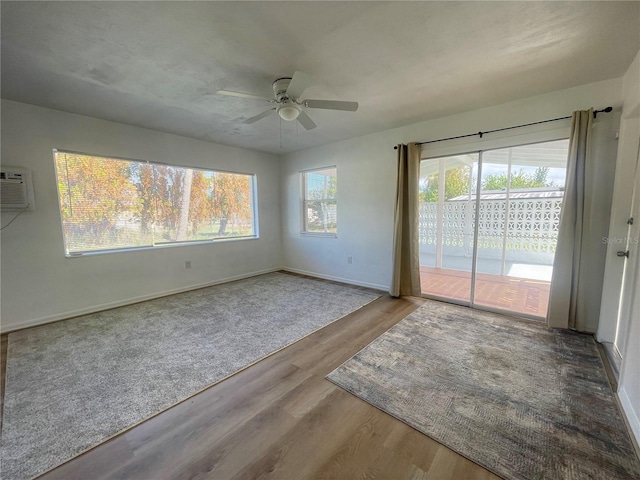 unfurnished room with hardwood / wood-style floors, ceiling fan, and a wall unit AC