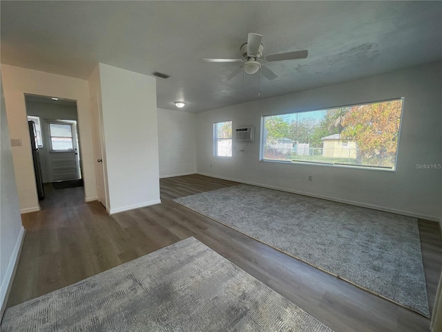 spare room with ceiling fan, plenty of natural light, and dark hardwood / wood-style floors