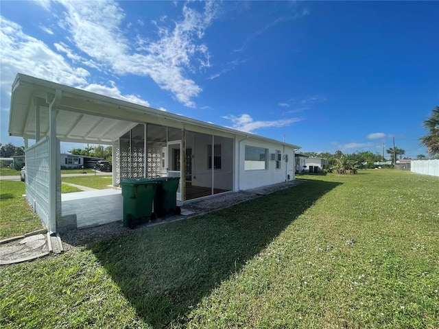 view of side of property with a lawn and a sunroom