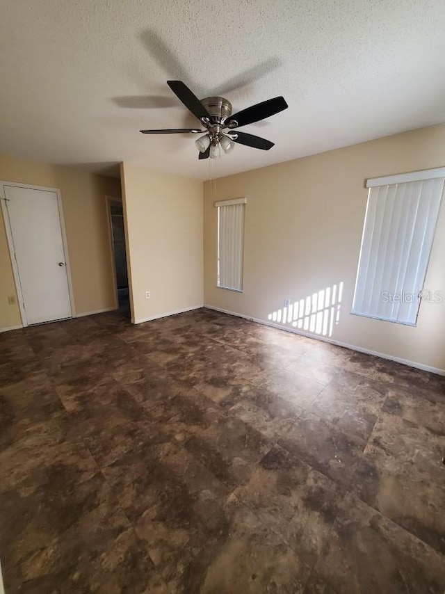 spare room featuring ceiling fan and a textured ceiling