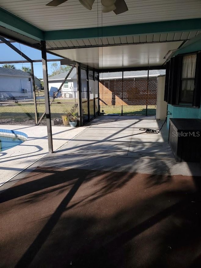 view of patio with a lanai, ceiling fan, and a swimming pool