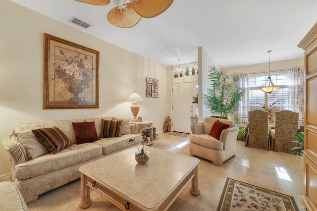 living room with ceiling fan with notable chandelier