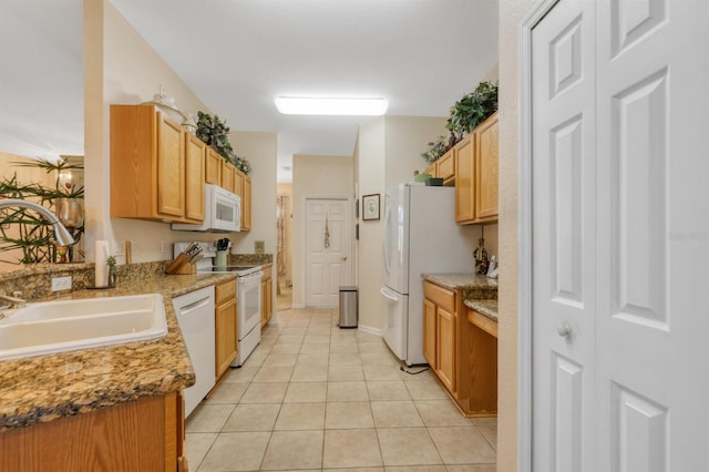 kitchen featuring light tile patterned flooring, white appliances, light stone countertops, and sink