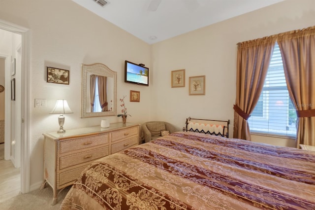 bedroom with multiple windows, ceiling fan, and light colored carpet