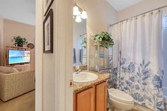 bathroom featuring curtained shower, vanity, and toilet