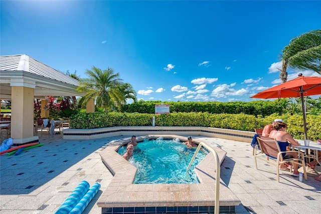 view of pool with a patio area and a hot tub