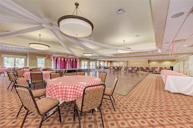 carpeted dining room featuring a raised ceiling