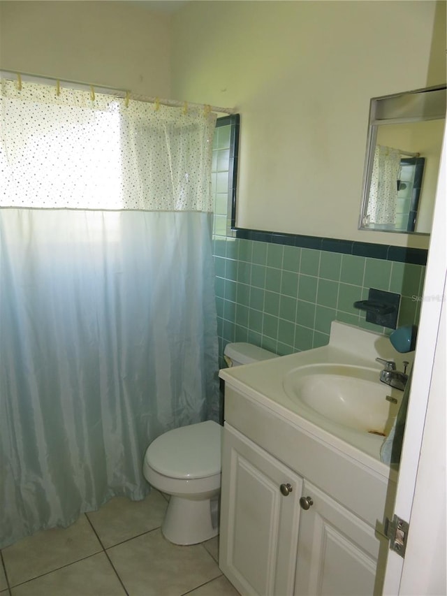 bathroom featuring a shower with curtain, tile patterned floors, toilet, vanity, and tile walls