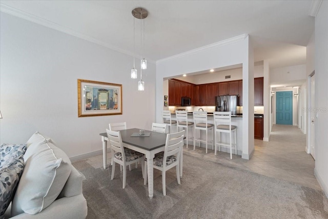 dining area with crown molding and light carpet