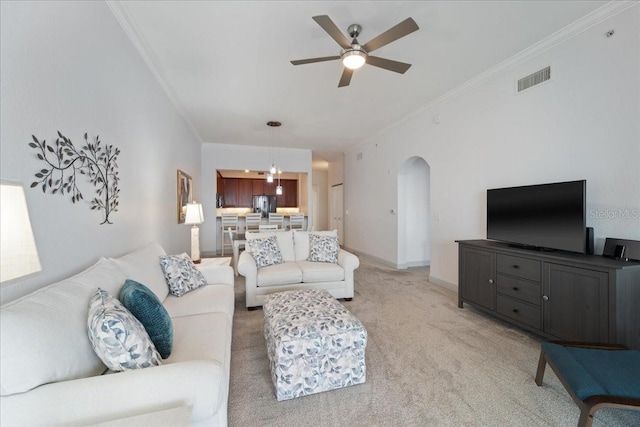 living room with carpet flooring, ceiling fan, and crown molding