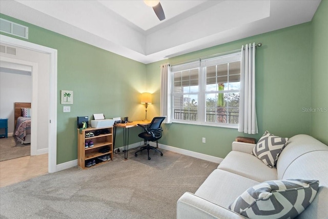 office featuring ceiling fan, carpet floors, and a tray ceiling