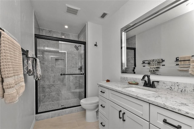 bathroom featuring tile patterned flooring, vanity, toilet, and an enclosed shower