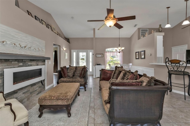 living room featuring a fireplace, light tile patterned floors, ceiling fan with notable chandelier, and high vaulted ceiling