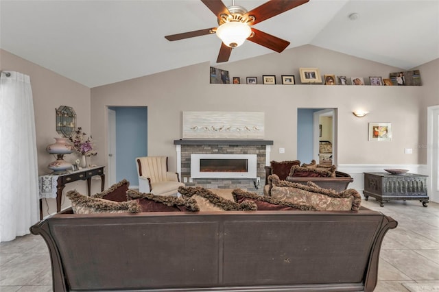 tiled living room featuring vaulted ceiling, ceiling fan, and a stone fireplace