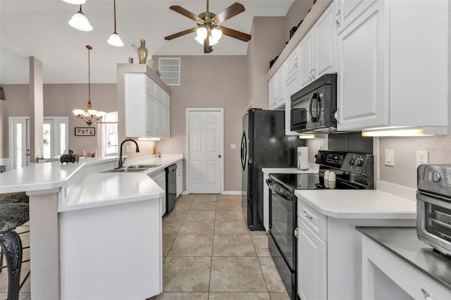 kitchen with black appliances, sink, light tile patterned floors, decorative light fixtures, and kitchen peninsula