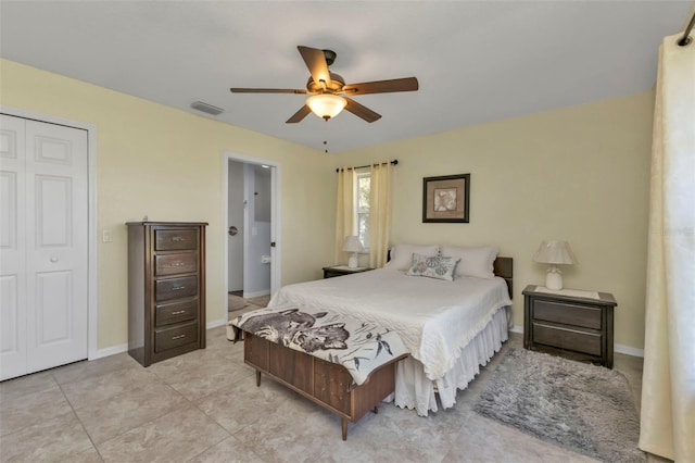 bedroom with ceiling fan, light tile patterned floors, and a closet