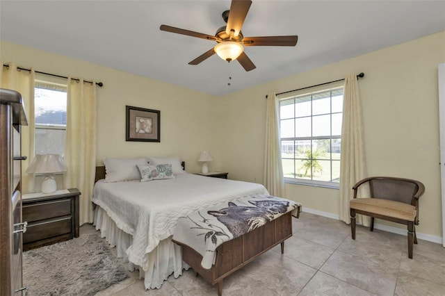 bedroom featuring multiple windows, ceiling fan, and light tile patterned floors