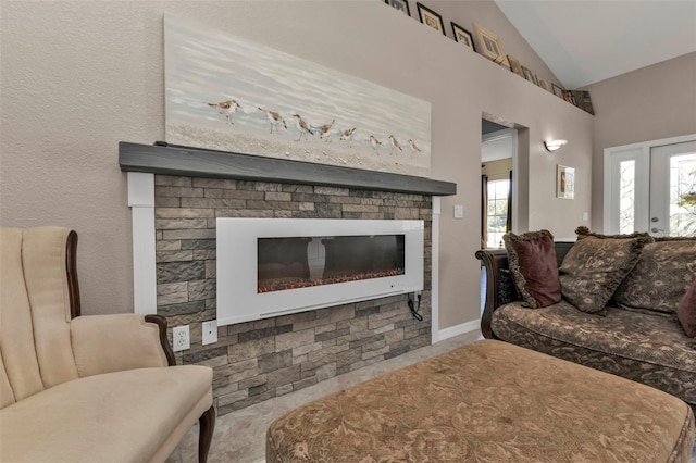 living room with a glass covered fireplace and vaulted ceiling