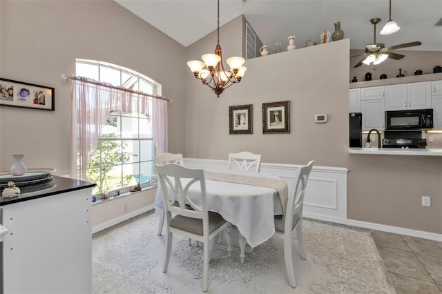 dining space with visible vents, ceiling fan with notable chandelier, baseboards, light tile patterned floors, and lofted ceiling