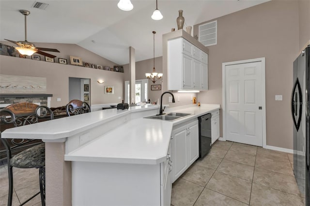 kitchen featuring a breakfast bar, a peninsula, a fireplace, a sink, and black appliances