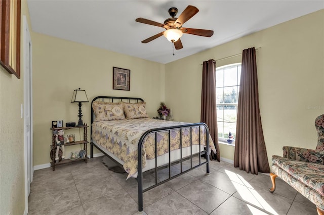 bedroom featuring light tile patterned floors, a ceiling fan, and baseboards