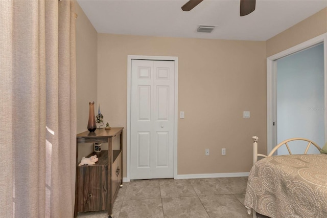 bedroom featuring light tile patterned floors, visible vents, baseboards, and a ceiling fan
