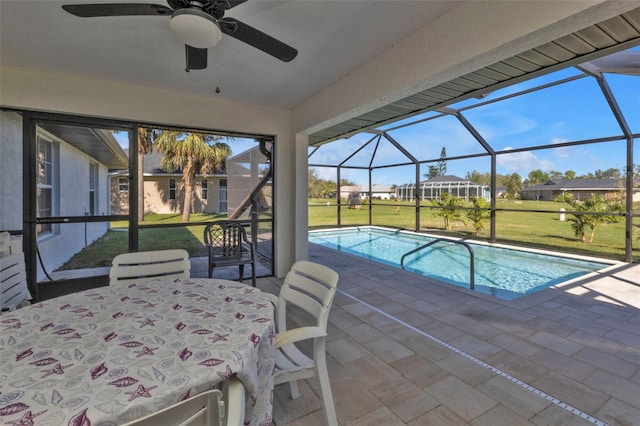 pool featuring outdoor dining space, a ceiling fan, a patio, a yard, and glass enclosure