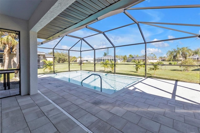 pool with glass enclosure, a yard, and a patio area
