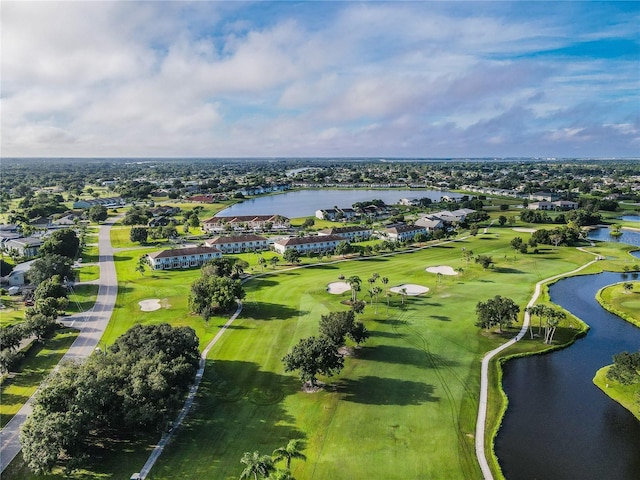 drone / aerial view with golf course view and a water view
