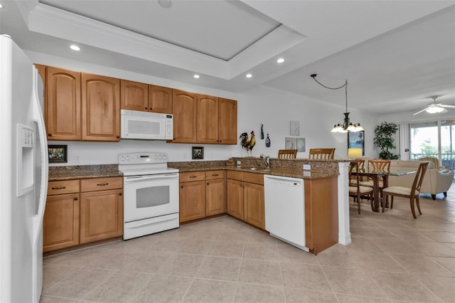 kitchen featuring kitchen peninsula, white appliances, ceiling fan with notable chandelier, sink, and decorative light fixtures