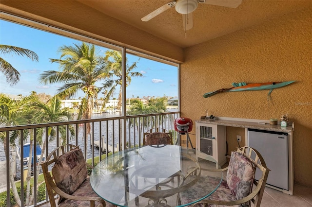 balcony featuring ceiling fan and a water view