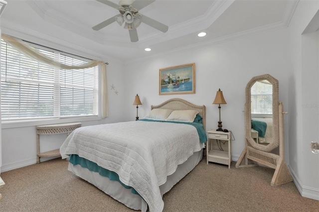 bedroom featuring a raised ceiling, multiple windows, ornamental molding, and ceiling fan