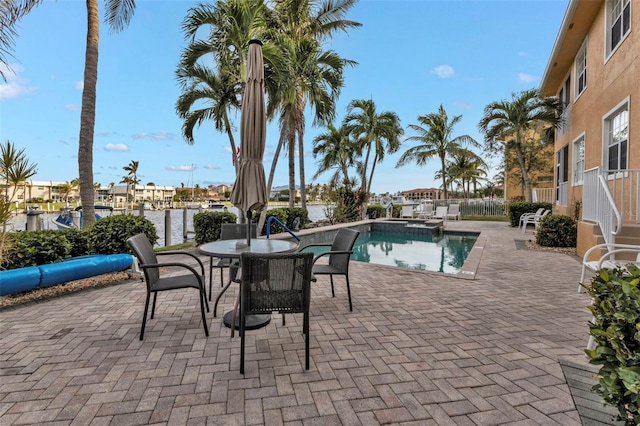 view of pool with a patio area and a water view