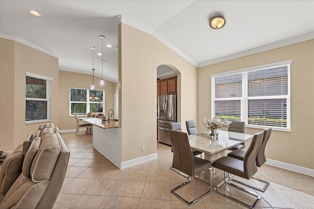 dining space with light tile patterned floors, vaulted ceiling, a wealth of natural light, and ornamental molding