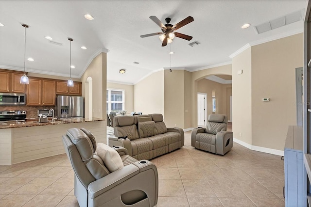 tiled living room with a wealth of natural light, crown molding, and ceiling fan